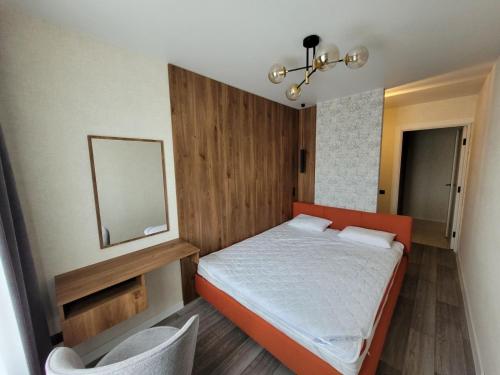 a small bedroom with an orange bed and a mirror at Апартаменты на Титова in Dnipro