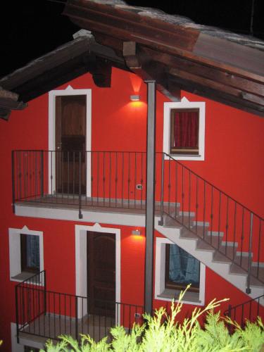 a red building with balconies on the side of it at B&B La Maison D' Amelie Camere e Appartamenti in Fenis