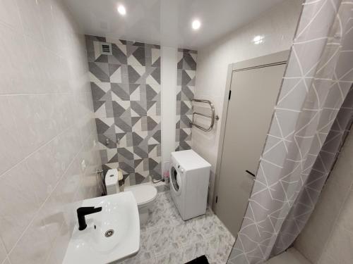 a white bathroom with a toilet and a sink at Апартаменты на Титова in Dnipro