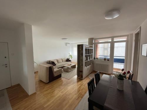 een woonkamer met een bank en een tafel bij New Belgrade apartment in Belgrado