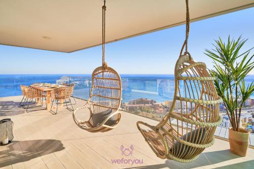 een balkon met schommels en een tafel met uitzicht bij weforyou Med One Exclusive Sea Views 3 Bedrooms Apartament A 3A in Fuengirola