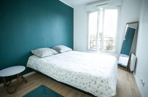 1 dormitorio con cama blanca y ventana en **La Kreolita** near Paris / Disneyland Paris, en Meaux