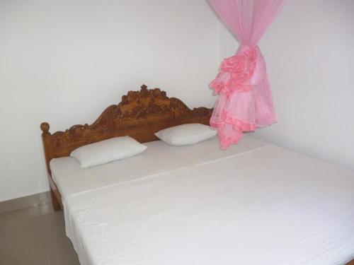 a bedroom with a bed with a dress on it at SeaView Paradise Inn in Weligama