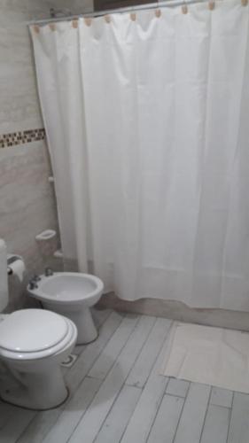 a white bathroom with a toilet and a shower at Polo Austral in Ushuaia