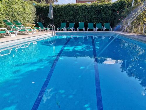 a swimming pool with chairs and a swimming pool at Residencial Playa Lisa in Boadilla del Monte