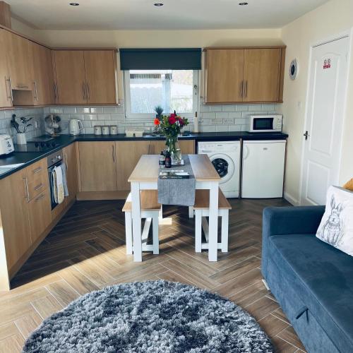 a kitchen and living room with a table and a couch at Ramblers Rest Modern Cottage-Perfect Views of Ben Nevis in Fort William