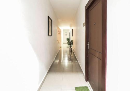 a hallway with white walls and a hallway with a door at Euphoria Extended Stays - OMR IT Expressway Chennai in Chennai
