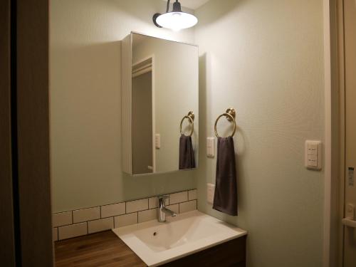 a bathroom with a sink and a mirror at 民泊 桔梗 in Awaji