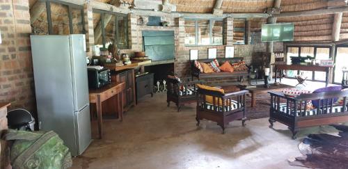 a kitchen with chairs and a refrigerator in a room at The Lapa in Durban