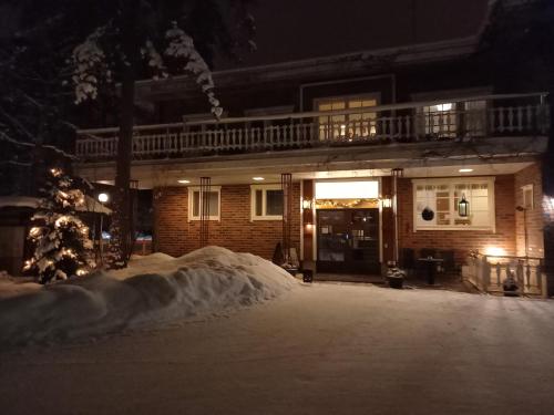 a house is covered in snow at night at Hotelli-Ravintola Gasthaus Lohja in Lohja