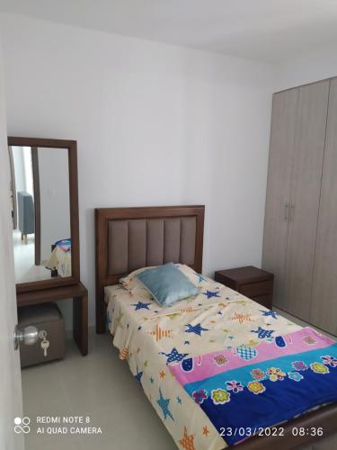 een slaapkamer met een bed en een spiegel bij Apartamento Loft in Bucaramanga