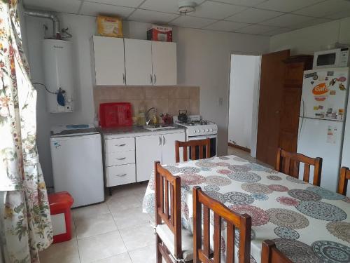 cocina con mesa y cocina con electrodomésticos blancos en Casa de descanso para 6 en Tandil en Tandil