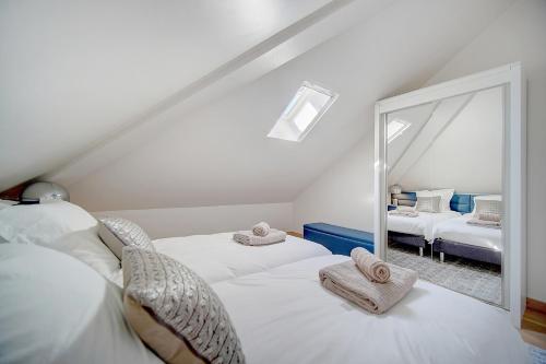 - une chambre mansardée avec 2 lits et un miroir dans l'établissement Cannes banane 50m croisette, luxueux 4 pièces dans résidence de standing, à Cannes