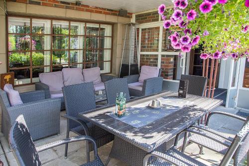 a table and chairs on a patio with purple flowers at Hotelli-Ravintola Gasthaus Lohja in Lohja