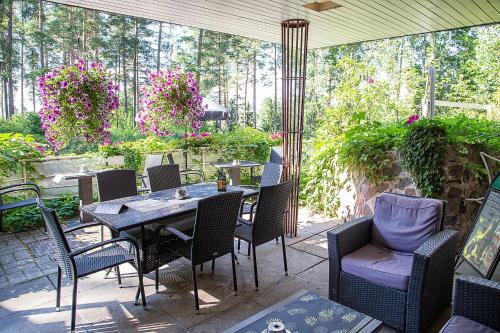 a patio with a table and chairs and flowers at Hotelli-Ravintola Gasthaus Lohja in Lohja