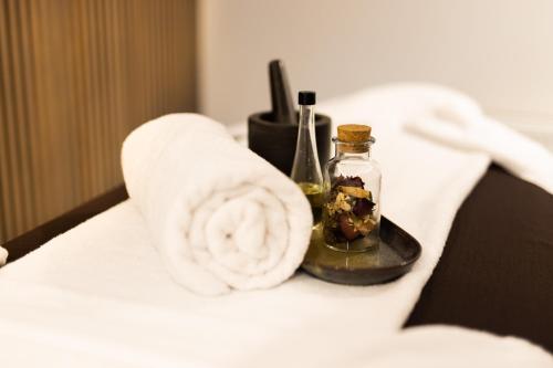 a towel and a bottle with a candle on a bed at TRIBE Riga City Centre in Rīga