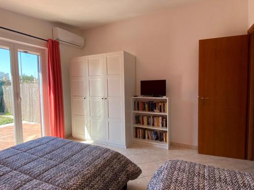 a bedroom with a bed and a tv and a book shelf at The House Fiera di Roma Aeroporto Fiumicino in Ponte Galeria