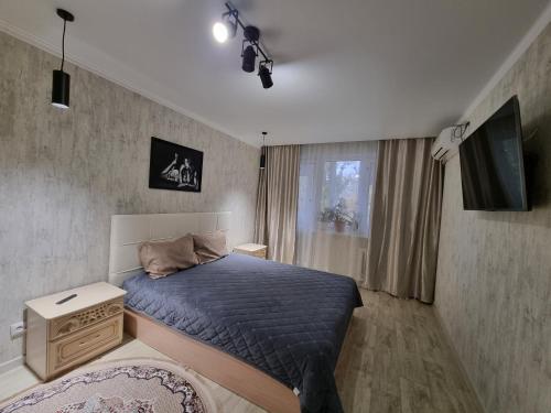 - une chambre avec un lit et une télévision dans l'établissement Посуточная квартира на Кердери с Wi-Fi, à Uralsk