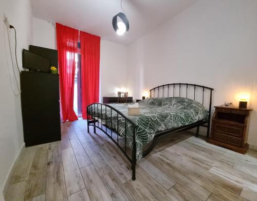 a bedroom with a bed and a table and red curtains at Kos in Florence