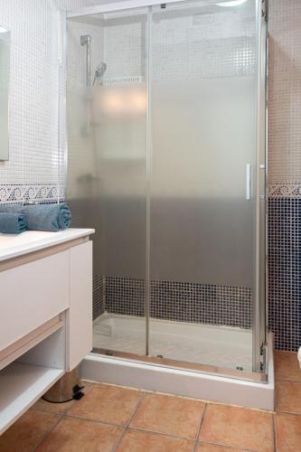 a bathroom with a shower with a glass door at El Rincon - No Stress Holidays in El Cotillo