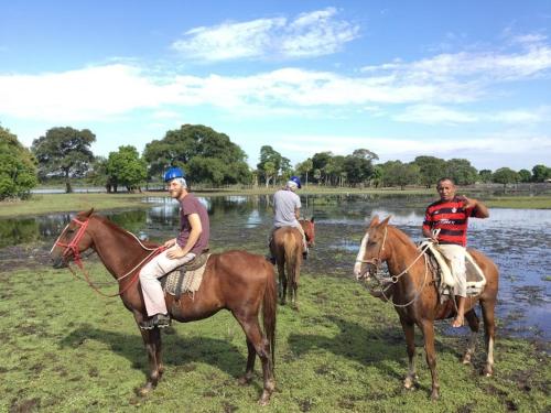 eine Gruppe von Menschen, die an einem Fluss reiten in der Unterkunft Spot Jaguar Pantanal South Camping Wild Jaguar Tour in Corumbá