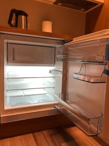 an empty refrigerator with its door open in a kitchen at EYVÍK Cottages - Private HOT TUB! in Selfoss