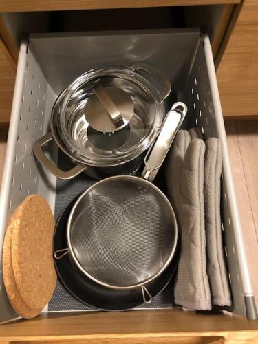a drawer filled with pots and pans and towels at EYVÍK Cottages - Private HOT TUB! in Selfoss