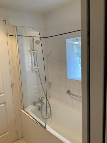 een badkamer met een douche en een bad bij Hôtel MADO in Le Crotoy