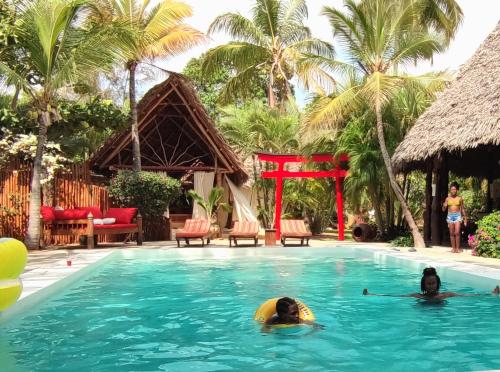 two people in the swimming pool at a resort at Lions' Luxury Eco Resort & Spa in Malindi
