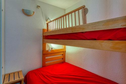 a bedroom with two bunk beds with red sheets at Orion 1416 in Villarembert