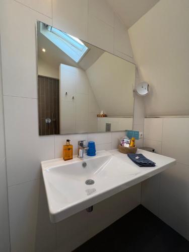 a bathroom with a white sink and a mirror at Mid83 in Woudsend