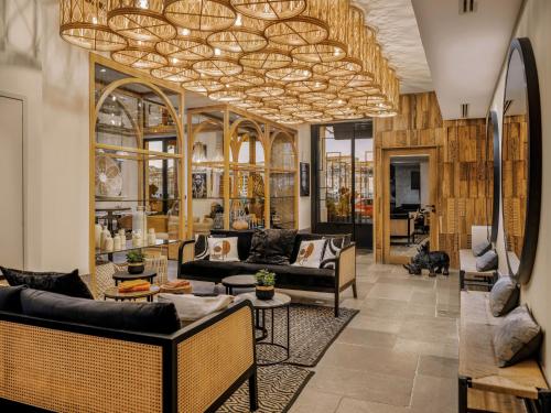 un soggiorno con divani e un lampadario di Maisons du Monde Hôtel & Suites - Marseille Vieux Port a Marsiglia