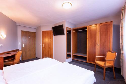 a bedroom with a bed and a desk and a tv at Hotel-Restaurant Weinhaus Grebel in Koblenz