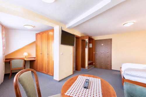 a room with a bed a table and a tv at Hotel-Restaurant Weinhaus Grebel in Koblenz