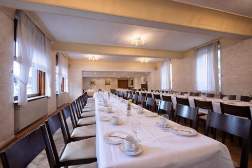 a long dining room with a long table with white table cloth at Hotel-Restaurant Weinhaus Grebel in Koblenz