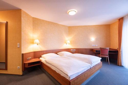 a bedroom with a bed and a table and chairs at Hotel-Restaurant Weinhaus Grebel in Koblenz
