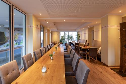 a long table in a restaurant with chairs and tables at Hotel-Restaurant Weinhaus Grebel in Koblenz