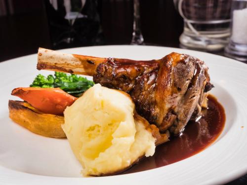 a plate of food with meat and vegetables on a table at Stirk House Hotel in Clitheroe