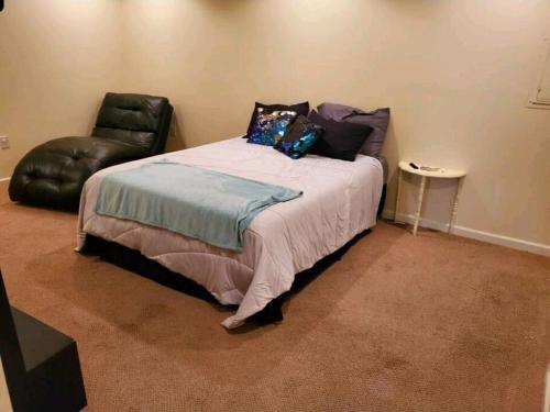 a bedroom with a bed and a leather chair at Why Not enjoy while away! in Harrisonburg