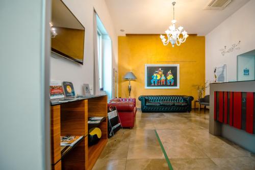 a living room with a couch and a chandelier at Hotel Bruman Salerno in Salerno