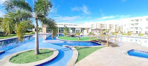 einen Pool mit einer Palme in einem Resort in der Unterkunft Muro Alto Condomínio Clube in Porto De Galinhas