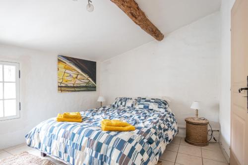 une chambre avec un lit avec des oreillers jaunes dessus dans l'établissement La Forge des Templiers, à Lorgues