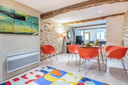 un salon avec des chaises orange et une table dans l'établissement La Forge des Templiers, à Lorgues
