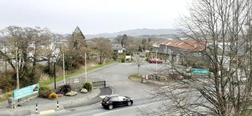 a car driving down a road in a town at Queens Rooms in Porthmadog