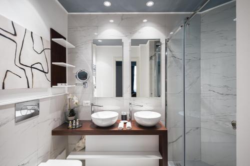 a bathroom with two sinks and a glass shower at Residenze Chamur- Grattacielo in Palermo