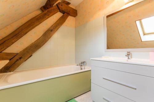 ein Badezimmer mit einer Badewanne und einem Waschbecken in der Unterkunft L'Escargot in Corgoloin
