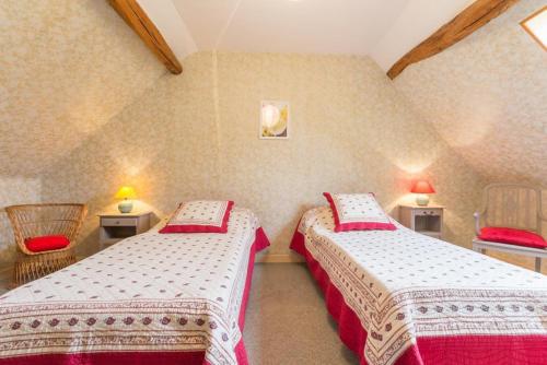 une chambre avec deux lits et deux chaises dans l'établissement L'Escargot, à Corgoloin