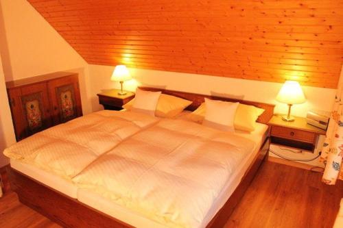 - une chambre avec un grand lit blanc et deux lampes dans l'établissement Ferienwohnung-Feldberg-in-der-Pension-Gloecklehof, à Todtnau