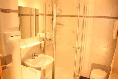 a white bathroom with a shower and a sink at Ferienwohnung-Feldberg-in-der-Pension-Gloecklehof in Todtnau