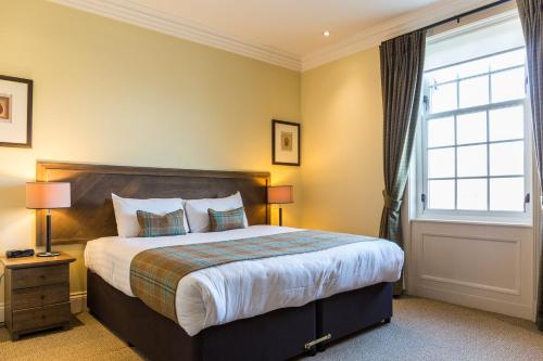 巴洛赫的住宿－Cameron Club Lodges，一间卧室设有一张大床和一个窗户。